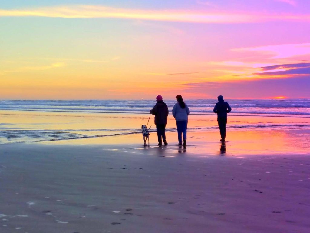 pismo rent colorful figures walking dog at sunset on beach